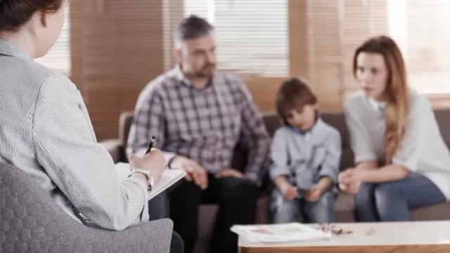 Aile Terapisi konulu görsel: anne, baba ve çocuklar psikologla birlikte oturuyor