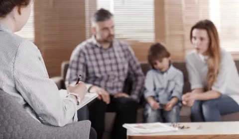 Aile Terapisi konulu görsel: anne, baba ve çocuklar psikologla birlikte oturuyor