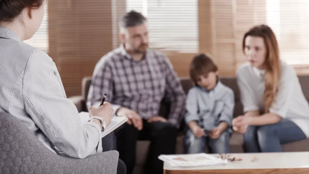 Aile Terapisi konulu görsel: anne, baba ve çocuklar psikologla birlikte oturuyor